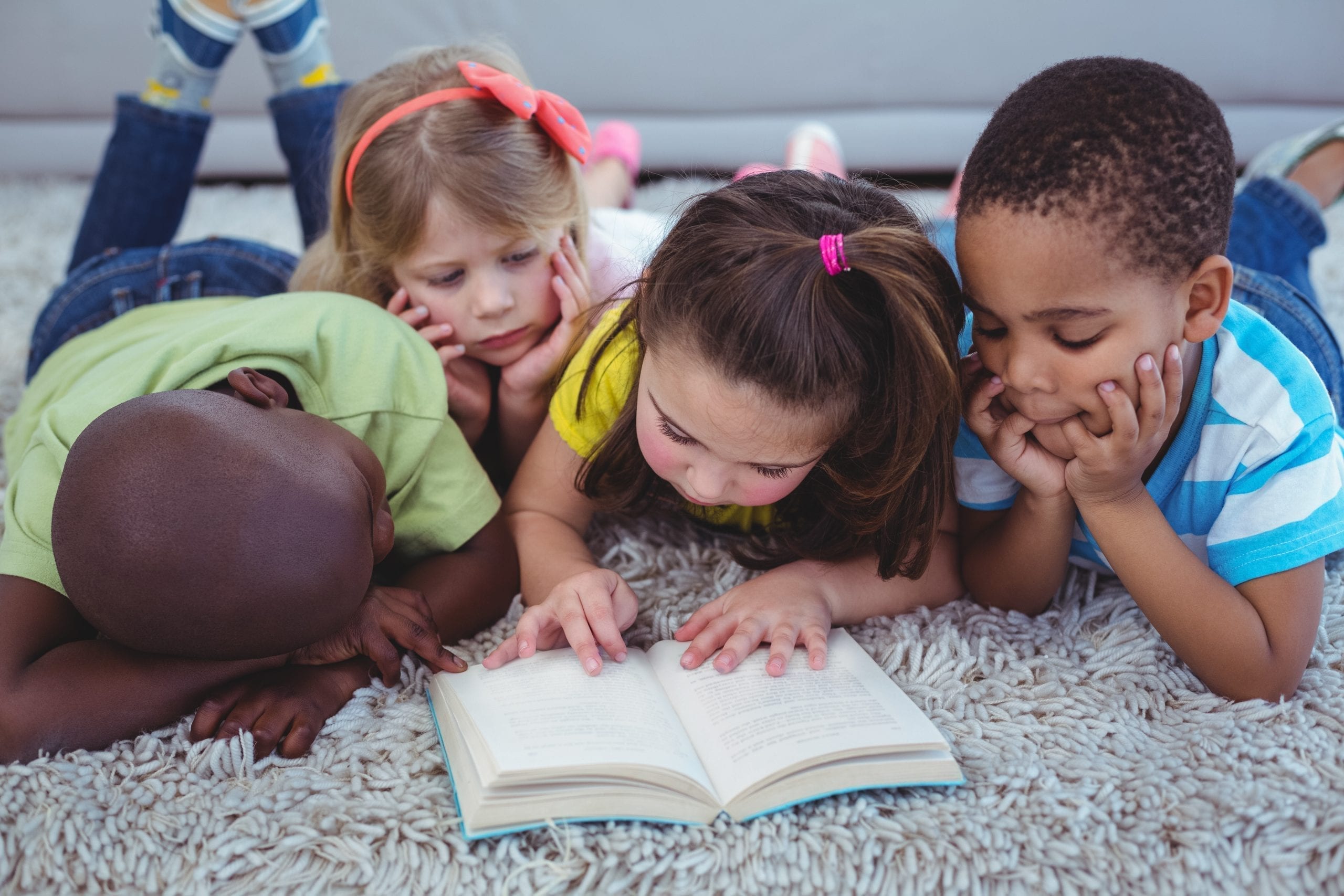 Happy kids reading a book together