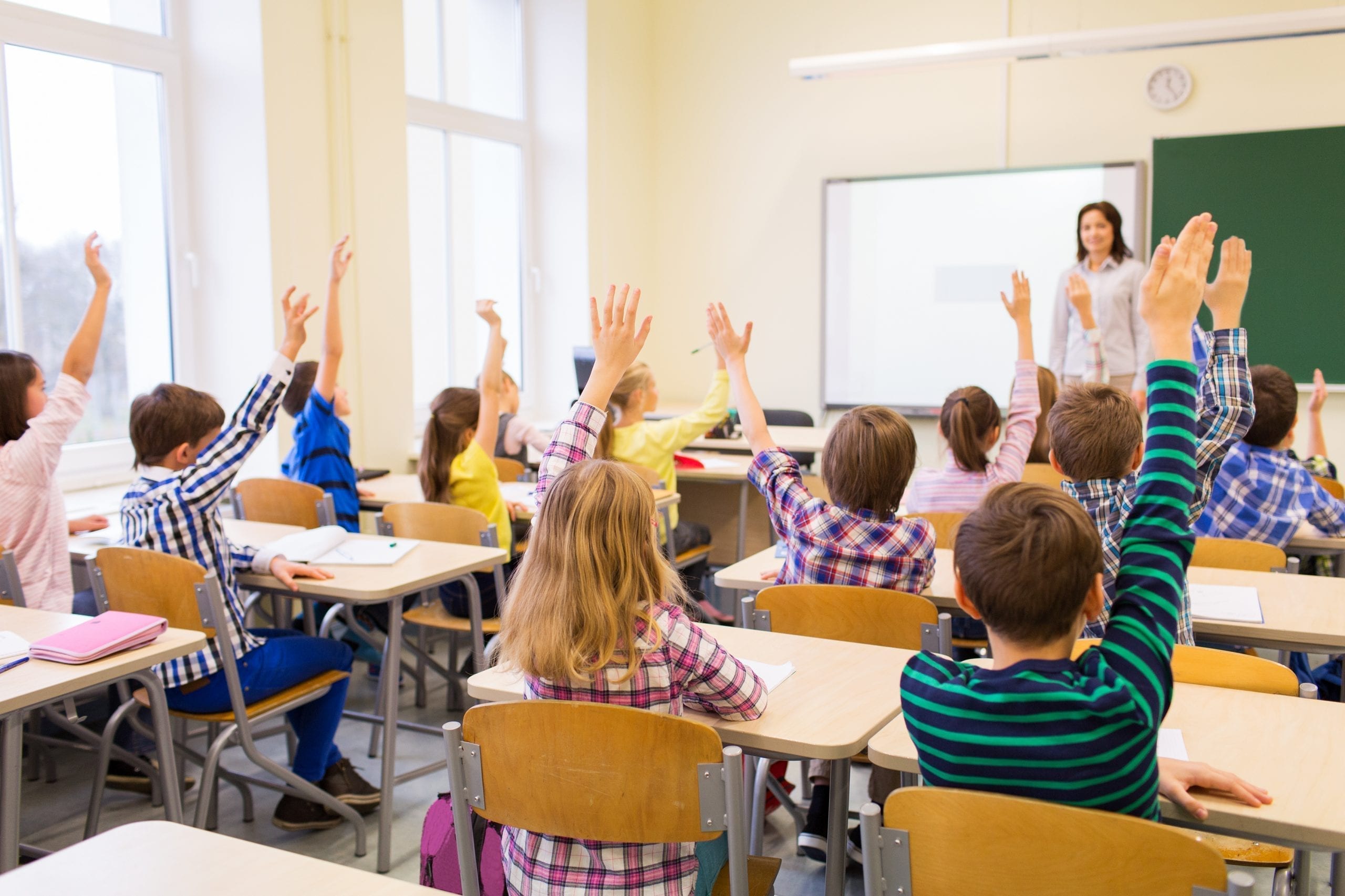 full classroom with their hands up
